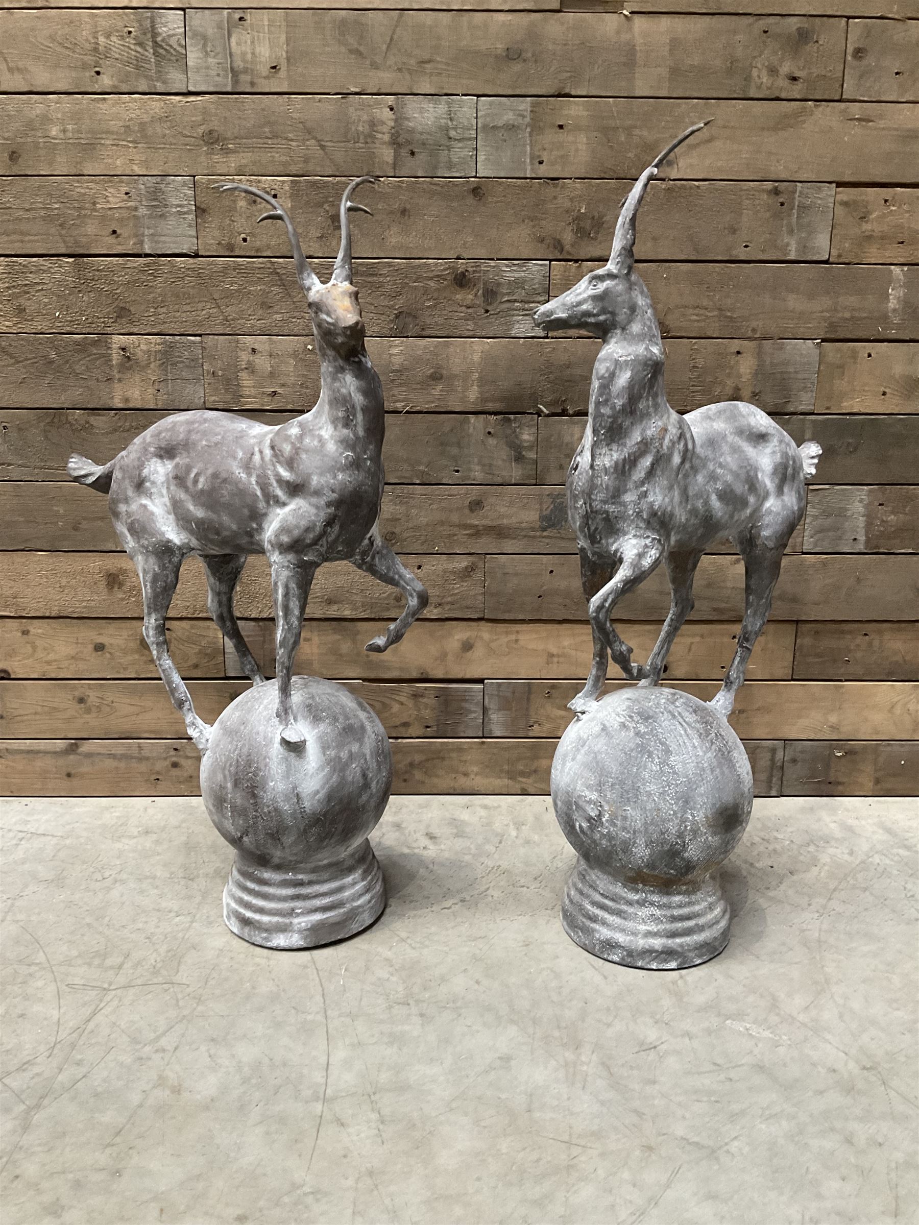 Pair of cast iron garden Stag figures or gate finials, raised on spherical ribbed base 