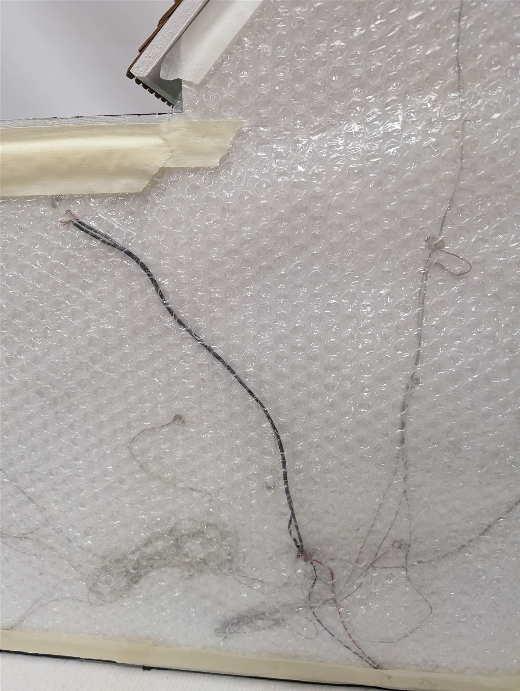 1:24 scale four-storey tudor-style dolls house, with black and white exterior, balcony garden, glazed panelled windows and wooden shingle roof, with decorated interior and wired fireplaces and lighting, H65cm, W58cm, D31cm, 