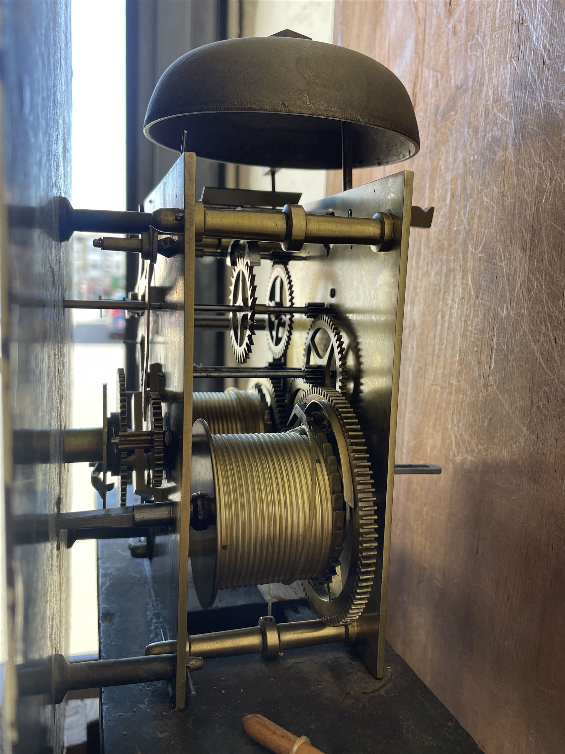An oak and mahogany longcase clock by William Hewson, Lincoln c 1860, with a swans neck pediment, ball and spire finials and brass paterae, break arch hood door flanked by reeded pilasters with brass capitals, oak trunk with canted corners and a short oak door with mahogany crossbanding, conforming plinth with applied skirting, fully painted dial with Roman numerals, minute track and subsidiary seconds dial, matching brass stamped hands and winding collets, depiction of a  sportsman to the break arch and corresponding game birds to the spandrels, dial pinned directly to an eight-day rack striking movement with a recoil anchor escapement, striking the hours on a bell. Original casemakers label pasted to the inside of the case 