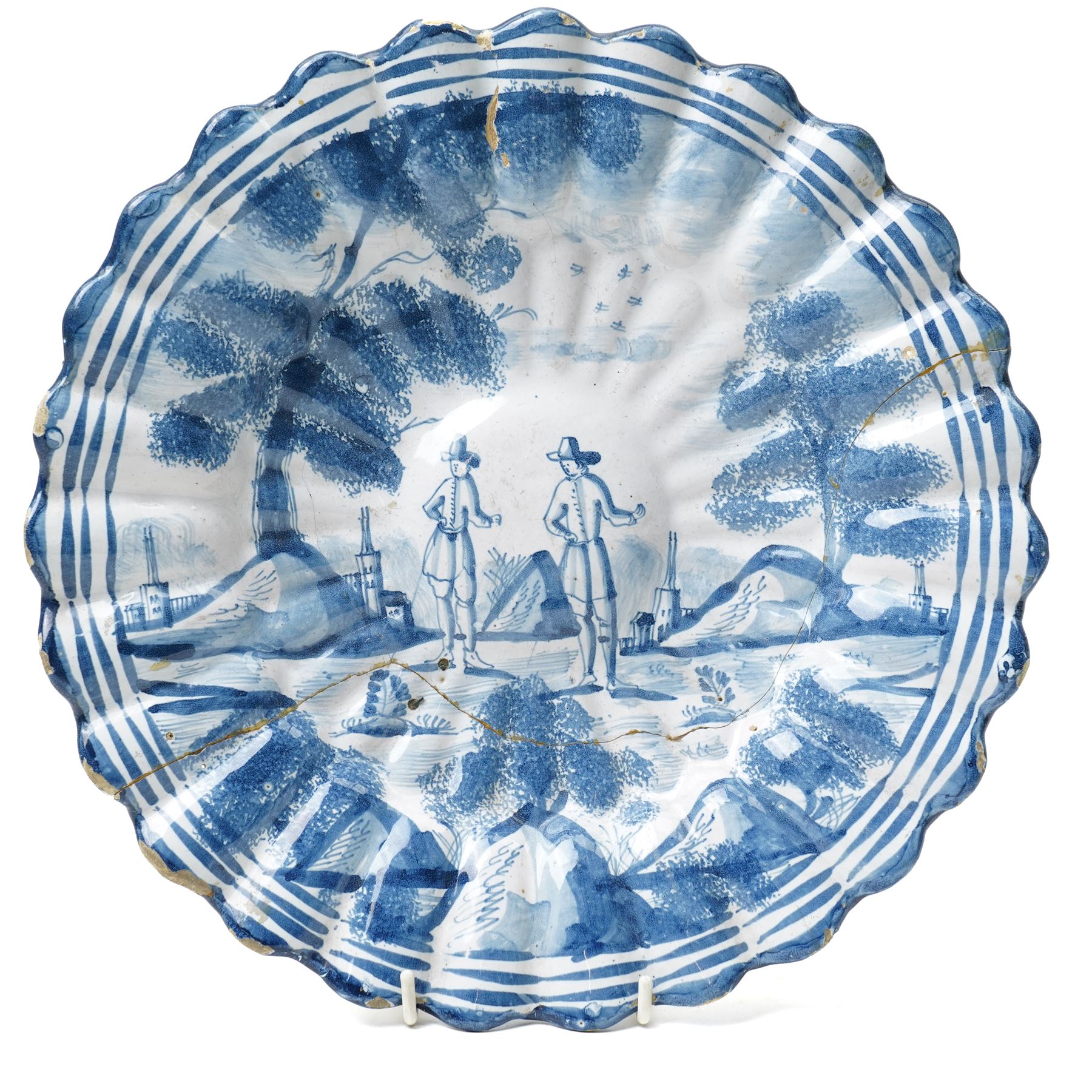 18th century Dutch Delft plate of fluted design decorated in blue and white with figures in a landscape D29cm and a Dutch Delft vase decorated in blue and white with oriental flowers H21cm (2)