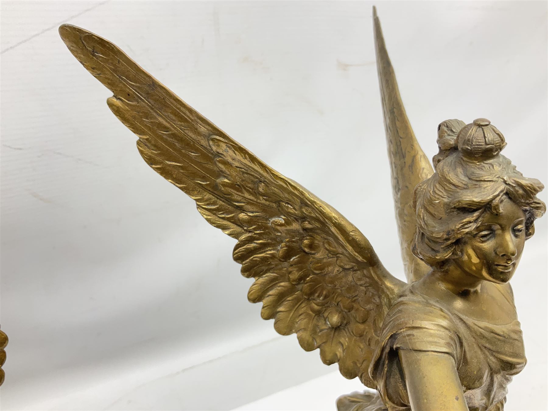 After Oswald Schimmelpfennig (German, 1872-1939): Pair of gilt bronze winged Allegorical female figures, the first example with arm outstretched holding a branch, signed 'Schimmelpfennig 1900', the second with arm raised above her head holding a book and sword in the other, both raised upon marble plinths, H45cm