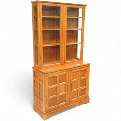 Light oak glazed cabinet on cupboard base, upper section of rectangular form with twin gla...