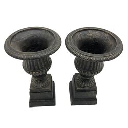 Pair of bronze finish small cast iron classical garden urns, on plinth bases
