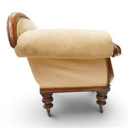 Victorian mahogany framed chaise longue, shaped button upholstered back with scroll-over end, padded seat and arm, moulded frame with carved scroll decoration, on turned supports with brass castors