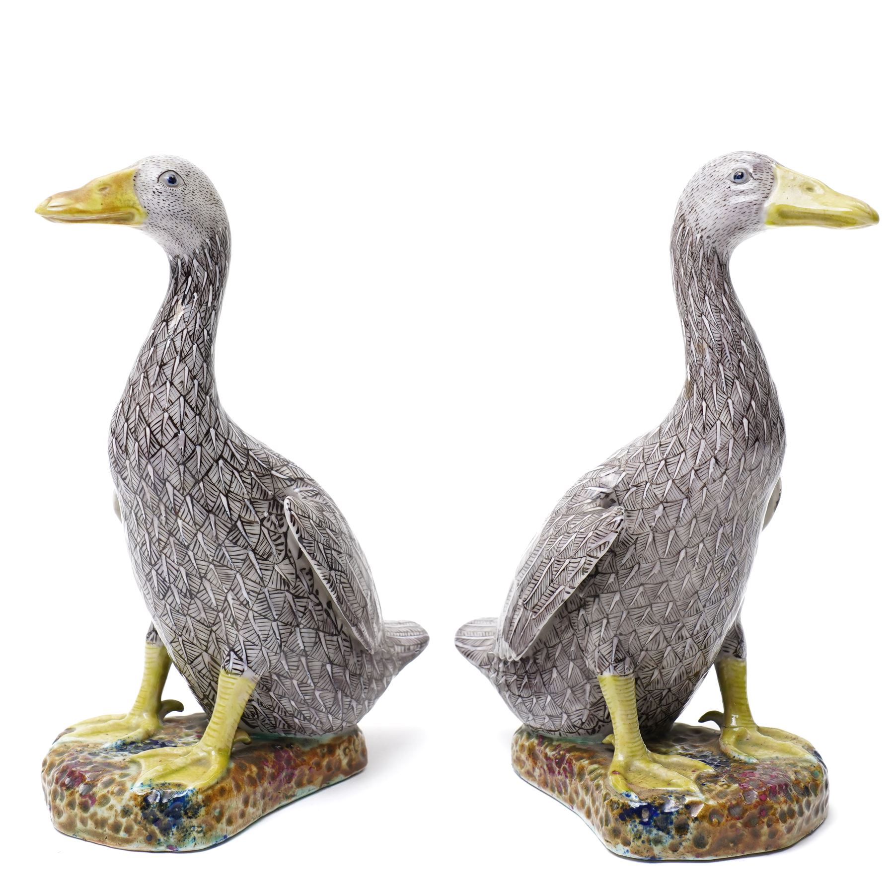 Pair of 20th century Chinese Export porcelain ducks, each naturalistically modelled with aubergine and white enamel plumage and seated on polychrome rockwork bases, H24cm 