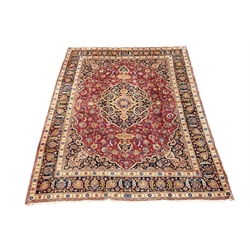  Persian Meshed plum ground rug carpet, large medallion decorated with Boteh motifs, overall floral design with stylised flower heads, repeating border with guards, signed by the maker, 380cm x 301cm  