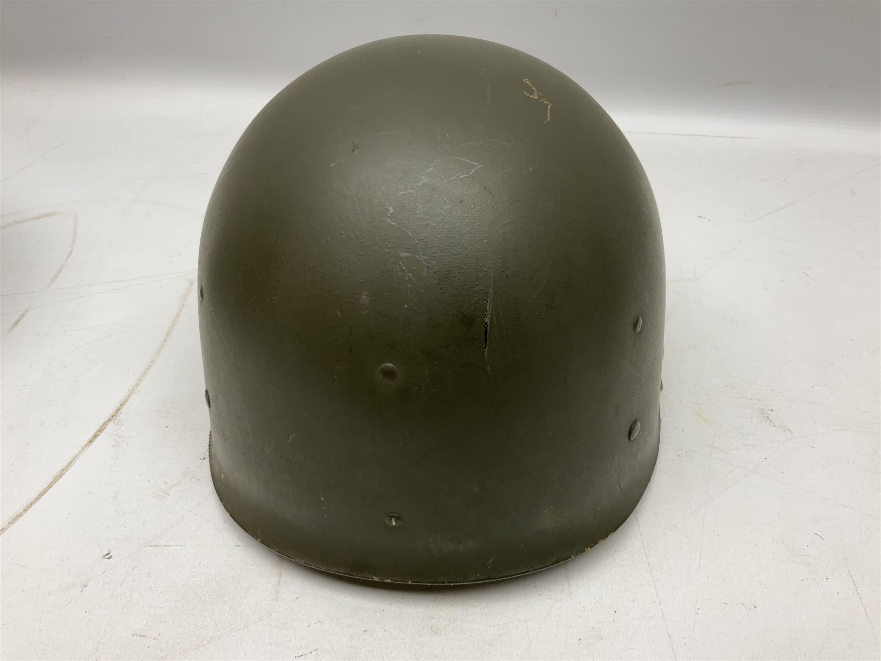 American first type paratrooper helmet with post-WW2 strap and D-rings and later 1944 liner bearing Firestone Tyre and Rubber Company mark; green textured finish