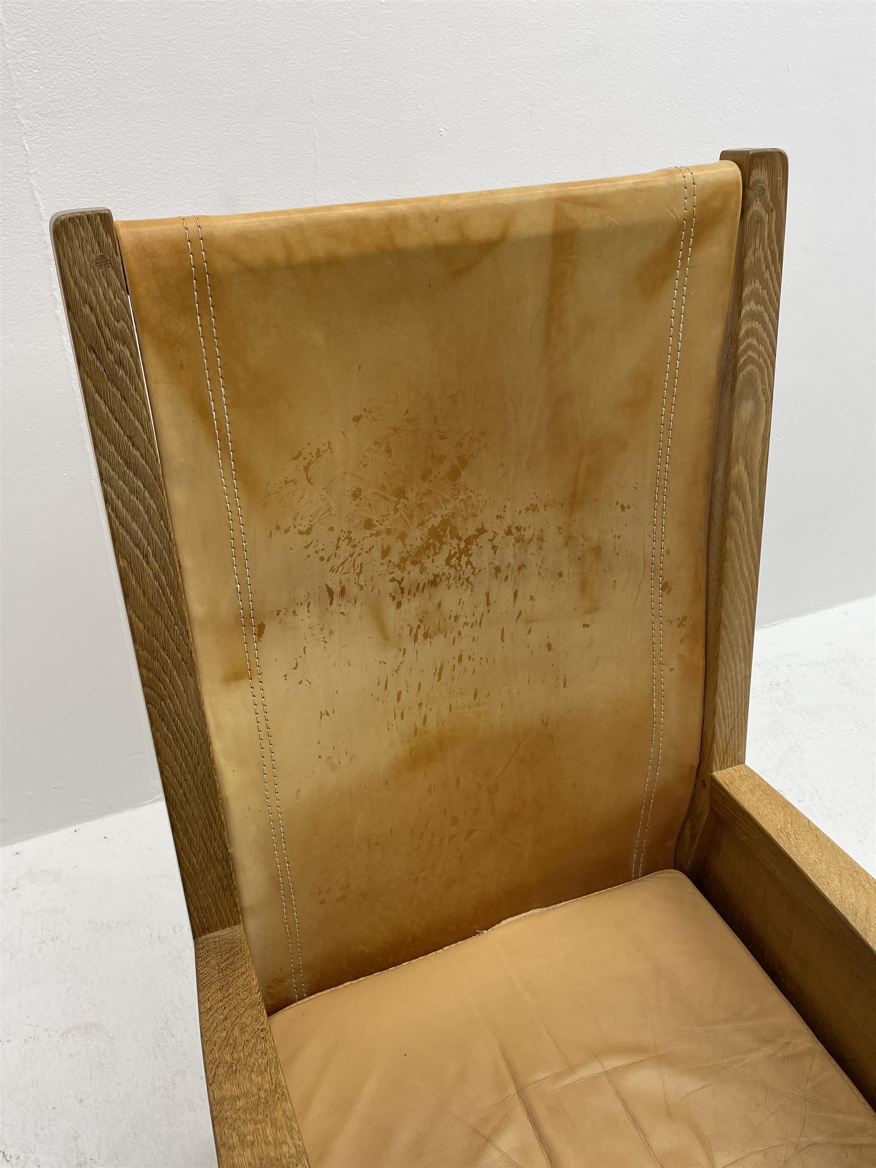 'Mouseman' oak smokers armchair, panelled sides, slung tan leather back and upholstered seat cushion, by Robert Thompson of Kilburn