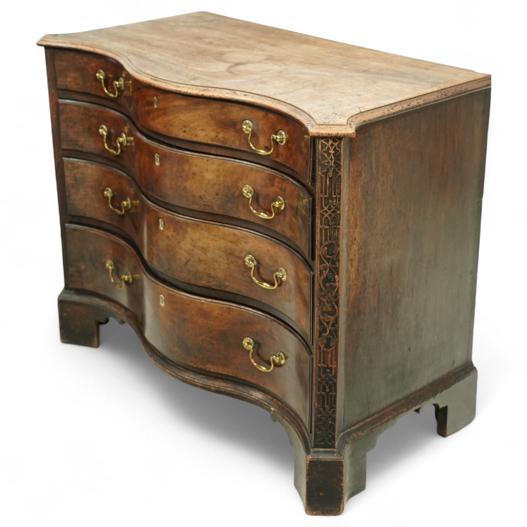 George III Chippendale period mahogany serpentine-fronted chest, shaped top with moulded edge over a deep serpentine outline with four graduated drawers, the canted corners decorated with blind-fretwork geometric decoration, fitted with brass swan-neck handles, lower moulded edge on bracket feet, circa 1760-1770