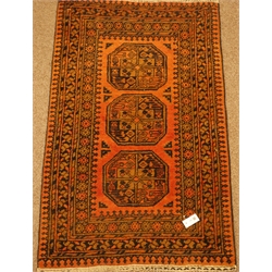  Persian Bokhara rust ground rug, decorated with triple Gul medallions, 82cm x 140cm  