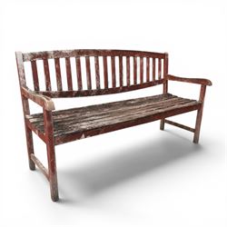 Teak garden bench, with slatted seat and spindle back, shaped armrests, finished in weathered red painted finish.