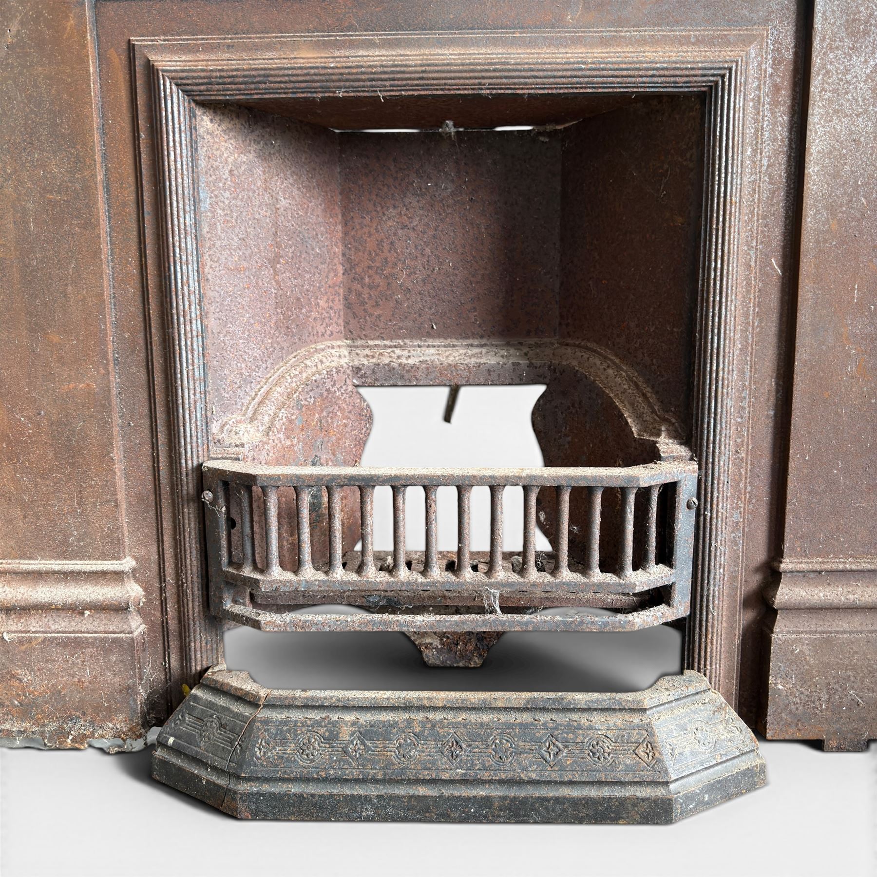 Late Victorian cast ion bedroom fireplace, decorated with floral poppy motifs and flluting
