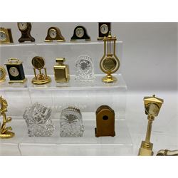 Collection of miniature clocks, predominantly with quartz movements, to include example modelled as an armchair, Edinburgh crystal glass example, clock modelled as a flower, sewing machine etc