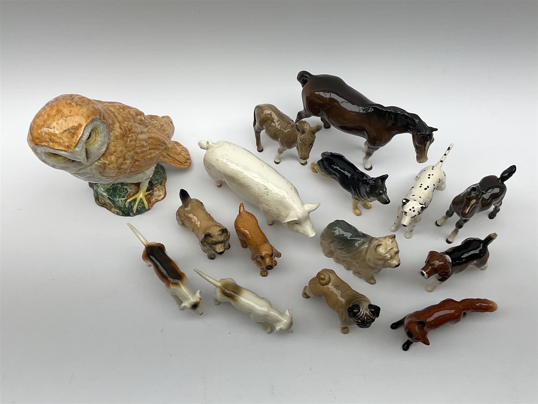 A group of Beswick figures, comprising Barn Owl 1046, various small dog figures including Yorkshire Terrier, Cairn Terrier, Dalmatian, Beagles, Pug, etc., CH Wall Champion Boy 53 pig, fox, donkey, horse, and foal. 