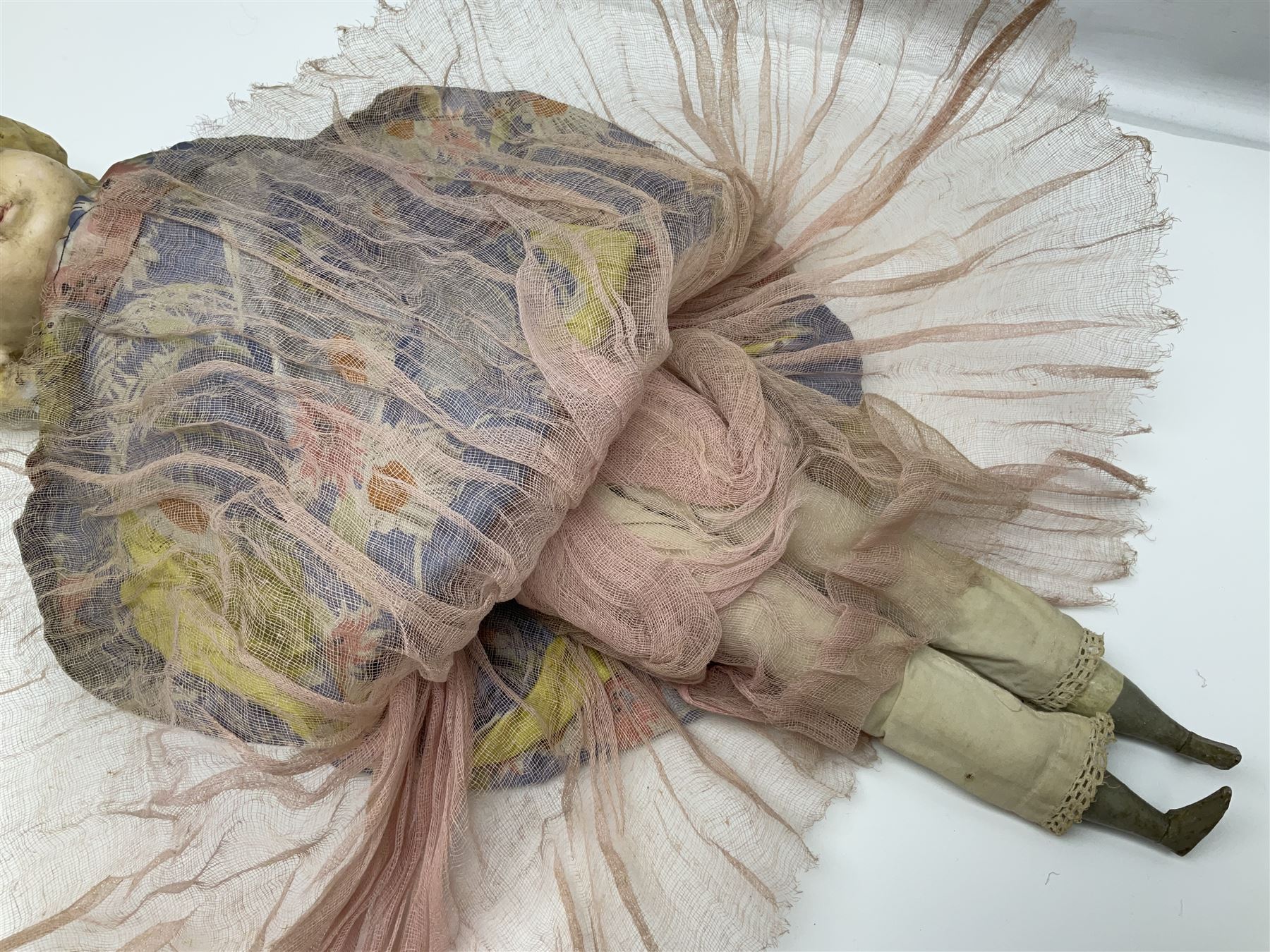 Victorian large wax over composition Pumpkin head doll, with inset dark glass eyes, moulded blonde hair in curls, stuffed body with carved and painted wooden limbs, grey painted boots, floral satin dress with netting underclothes H61cm