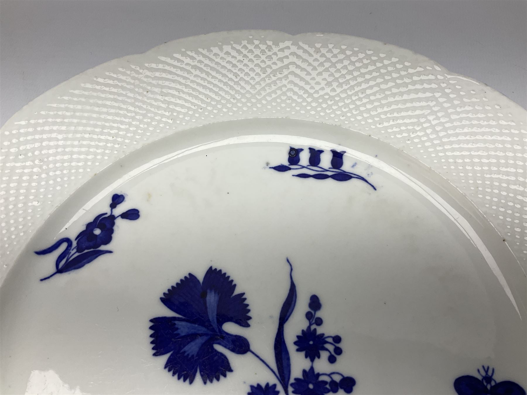 Three 19th century plates, comprising two circular examples and one oblong, each with osier moulded sides, the centres decorated in underglaze blue with Gillyflower type pattern, circular examples D25cm oblong example W27cm