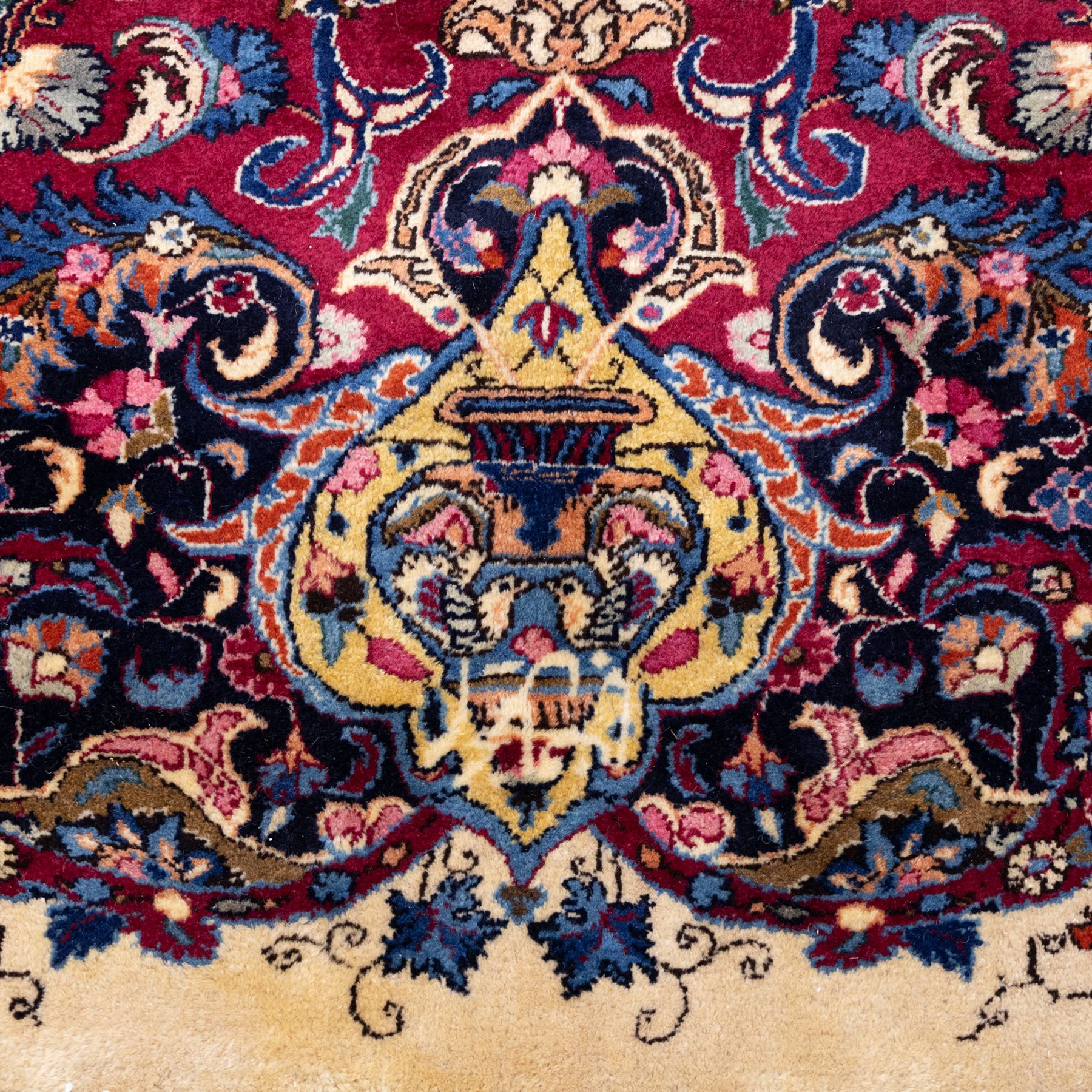 Large North East Persian Meshed hand-knotted carpet with signature, raspberry red field with central shaped cusped medallion, densely decorated with intricate arrangement of scrolling vines, and florals designs within conforming spandrels and a dark ground border richly ornamented with stylized flowers, vase and bird ornamentation, enclosed by guard stripes, with cotton fringe ends