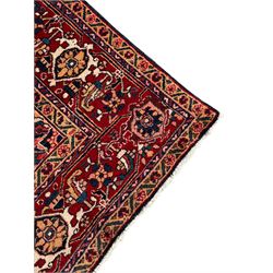 Persian Hamadan indigo and red ground carpet, large central medallion decorated with projecting palmette motifs, the surrounding field decorated with trailing branches and flower heads, crimson ground border decorated with stylised plant motifs, within floral pattern guard stripes 