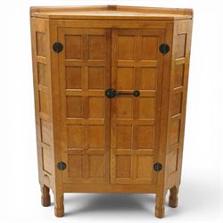 Mouseman - 1940's adzed and panelled oak corner cupboard, the raised quarter-gallery back ...