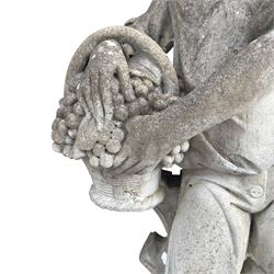 Haddonstone - weathered cast stone garden statue of a boy holding a basket of grapes, modelled with curled locks of hair wearing a tunic and breeches leaning against a naturalistic tree stump, on square base