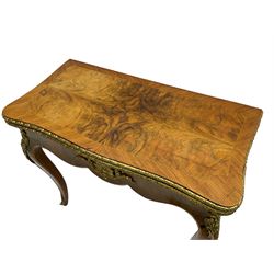 20th century French walnut and Kingwood card table, shaped fold-over top with figured quarter-matched veneers and floral egg and dart moulded edge in gilt metal, shaped aprons decorated with shell motifs with extending foliage, pull-out action base revealing storage well, on cabriole supports with ornate gilt metal mounts 