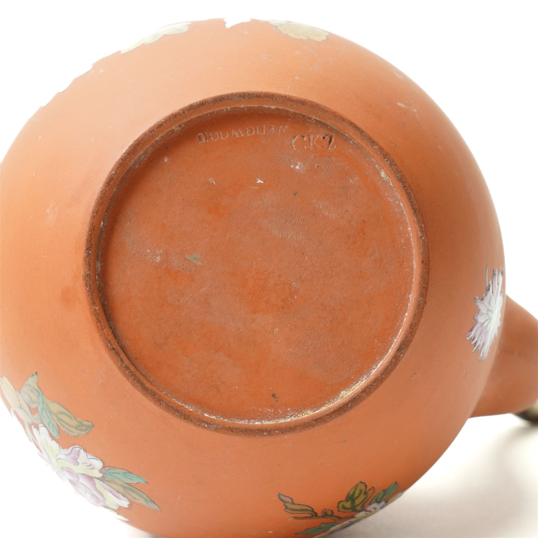 18th century creamware plate, painted with a chinoiserie landscape, D25cm; together with a Wedgwood terracotta jug, stamped to base, H15cm, and a Wedgwood Capri ware coffee pot, stamped to base, H19cm (3)