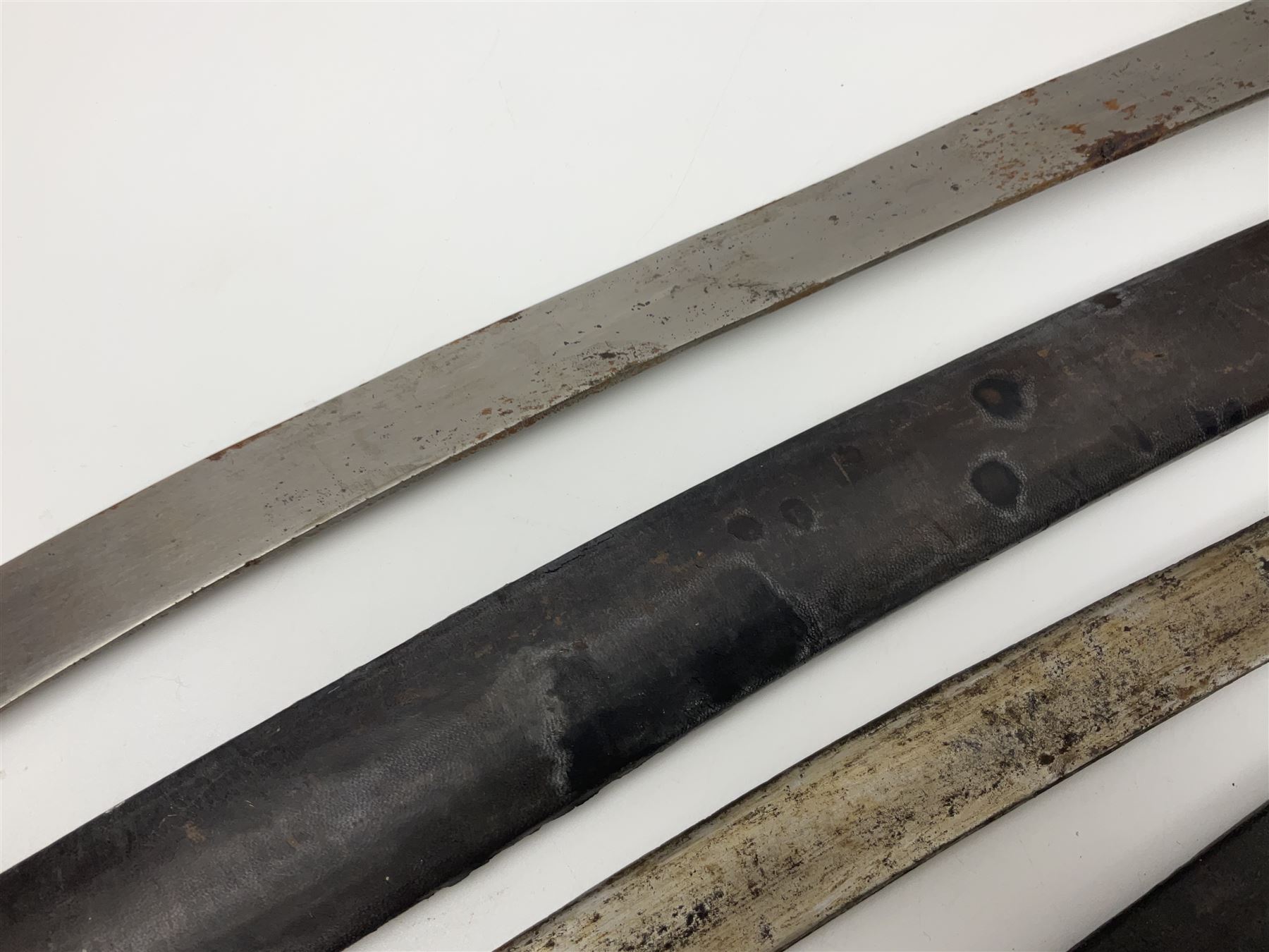 Four Indian tulwar swords; three with cast brass hilts and one with iron hilt; longest blade 81cm; all with scabbards (4)