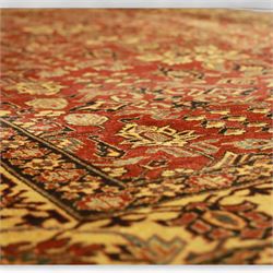Afghan Gazni Kazak rug, the hand-knotted wool pile featuring a rust red ground with all-over geometric floral motifs in ivory and dark green, enclosed by a wide ivory border with stylised rosettes and angular vine decoration, fringed ends, from the region of Ghazni, Afghanistan