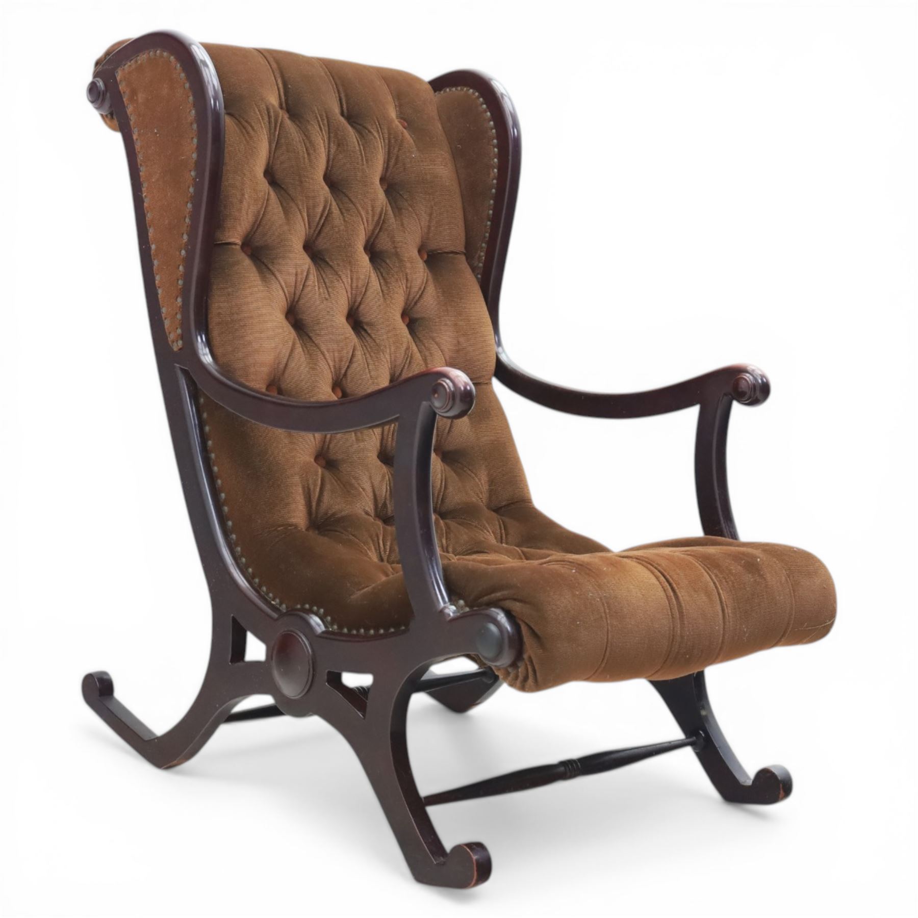 Late 20th century Regency style mahogany framed reading chair, the shaped and moulded frame with scrolled arms and open sides, upholstered in buttoned brown velvet, raised on curved supports terminating in scroll feet