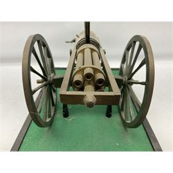 Scratch built brass model of an 1861 Gatling Gun with rotating barrels, hinged cover revealing mechanism, on metal bound wooden spoked wheels and rectangular base L47cm H22cm