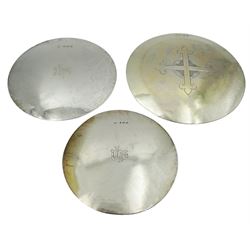 Three early 20th century silver and silver gilt patens, two examples engraved with initials, one with cross, hallmarked F A Barrett, Birmingham 1904, B & W Ltd, London 1934, and London 1932, makers mark worn and indistinct, largest example D14cm, approximate total weight 8.19 ozt (255 grams)