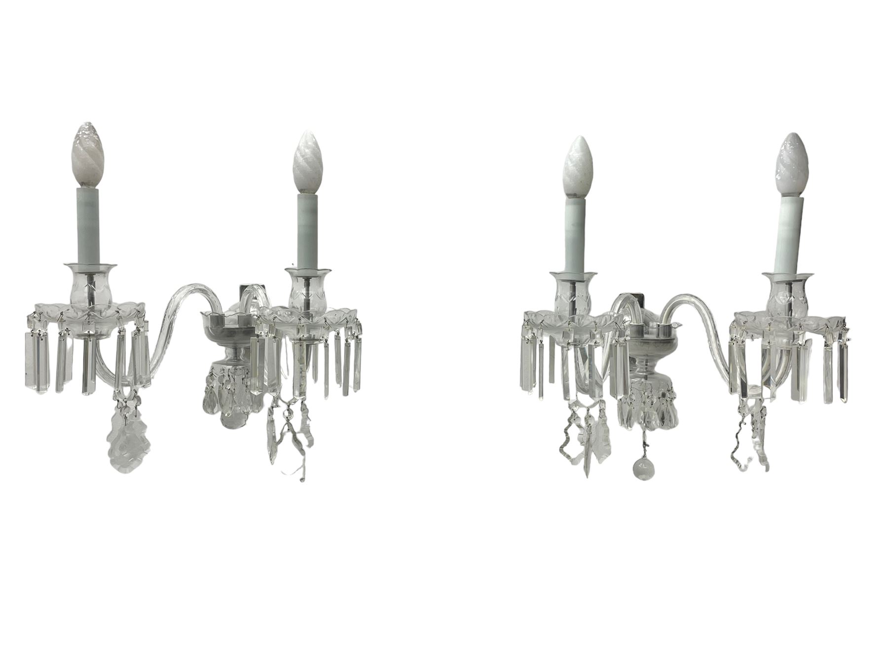 Pair of cut glass two branch wall sconce candelabras, each with S scroll extending branches with shaped and bevelled circular drip trays, hung with pendant drops