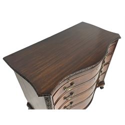 Chippendale design serpentine chest, shaped moulded top carved with repeating flower head motifs, fitted with brushing slide over four graduating drawers, pierced and foliate moulded handle plates with scrolled swan neck handles, canted upright corners carved with flower heads and strapwork, on canted ogee bracket feet