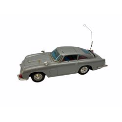 Gilbert Aoshin (Japan) James Bonds Aston Martin DB5 as seen in “Goldfinger and Thunderball” battery operated (untested) Tinplate model, silver with chrome trim, James Bond and Bandit figures, machine guns, bullet shield, ejector seat, revolving licence plate and extending tyre cutter; with part box lid only
