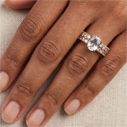 9ct gold aquamarine and blue topaz ring, single oval cut aquamarine, with two rows of round cut topaz's set either side, hallmarked