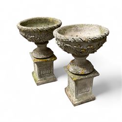 Pair of cast stone ornate garden urns, on plinth bases
