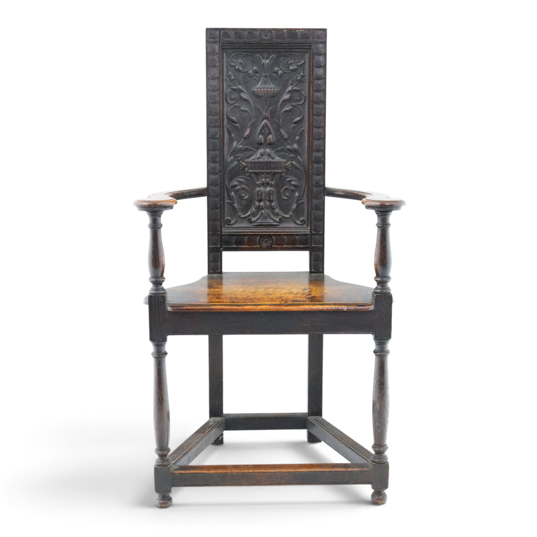 17th design century carved oak hall chair, carved back with urn and foliate details, shaped seat and arms, raised on turned supports united by stretchers