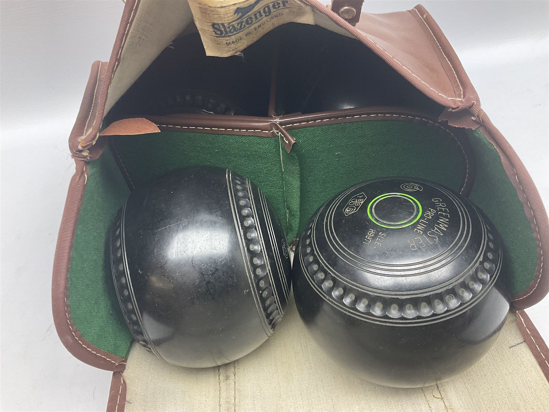Eight Greenmaster lawn green bowling balls, comprising set of four size
