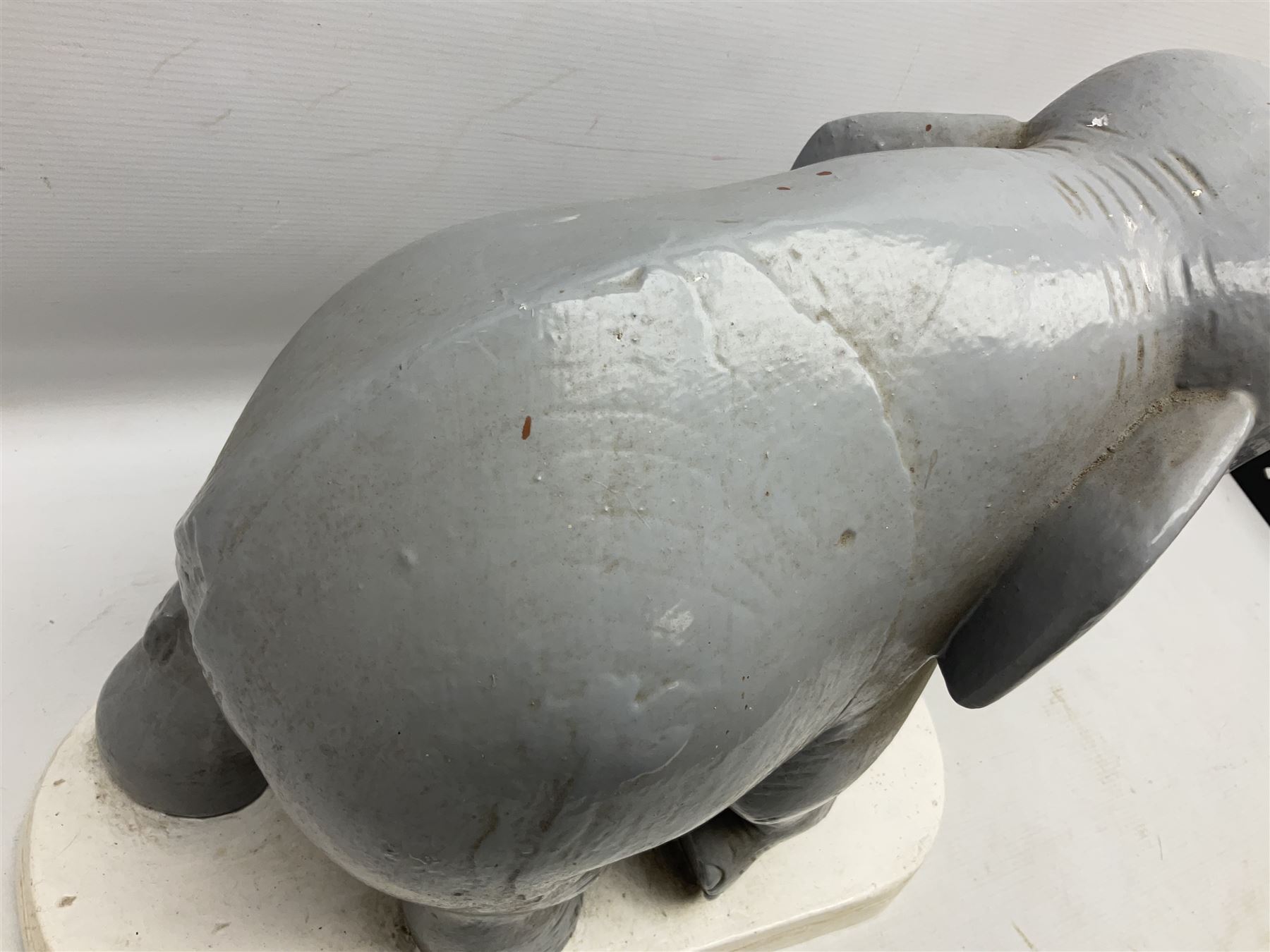 Composite figure of an elephant, painted grey, upon white base, L45cm H65cm