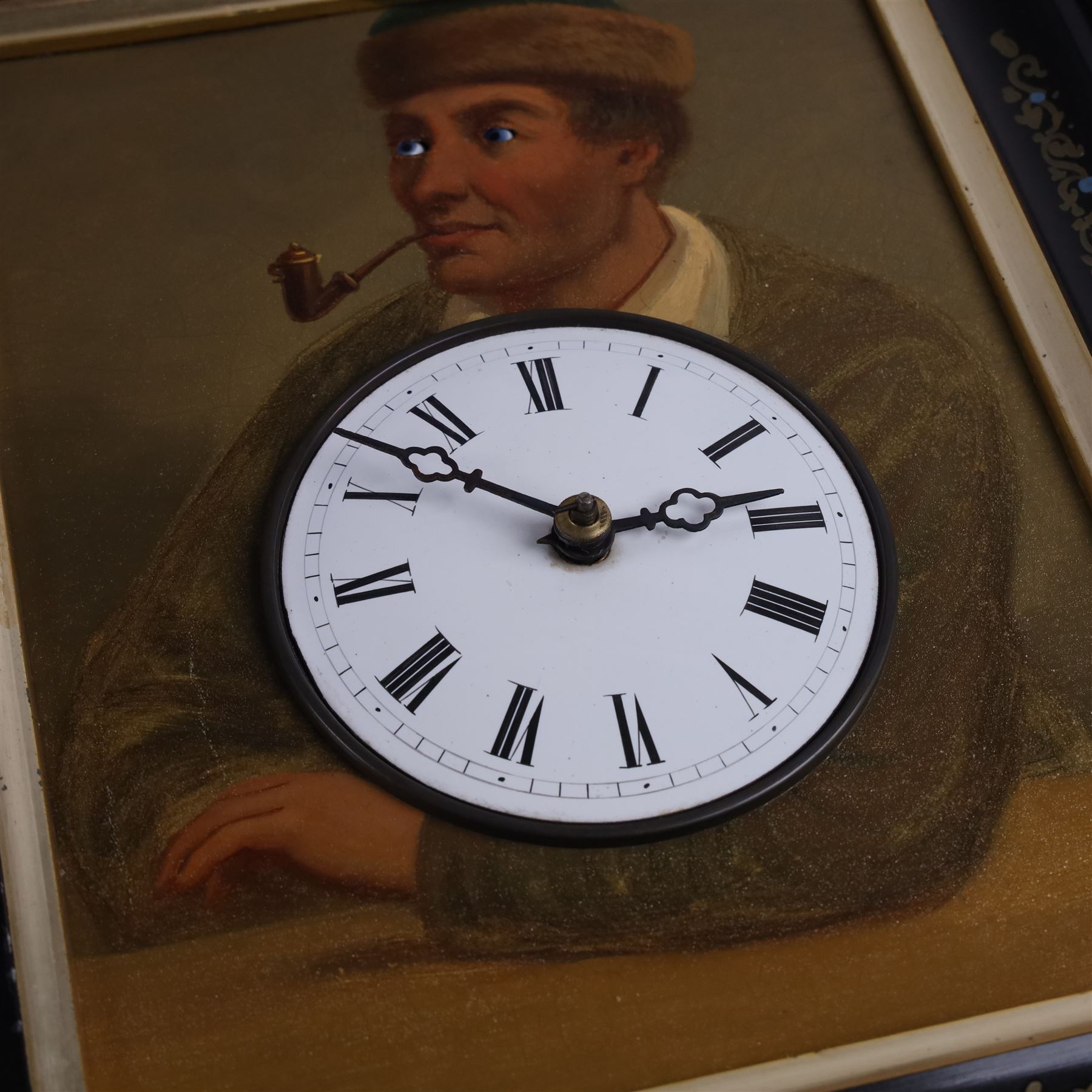 Mid-19th-century Black Forest 'Augenwender' moving eyes Cuckoo wall clock, stained wooden case with painted dial portrait of a man with a pipe and moving eyes, 30-hour brass plate movement striking on a coiled gong, and cuckoo strike together with weights and pendulum 

Literature: Schwarzwald-uhren, Berthold Schaaf (2008) p. 92-94
