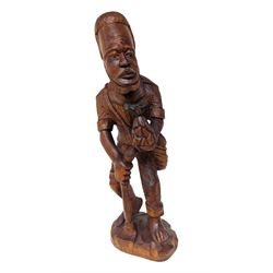 African carved wooden figure, modelled as a man holding a pineapple, H63cm