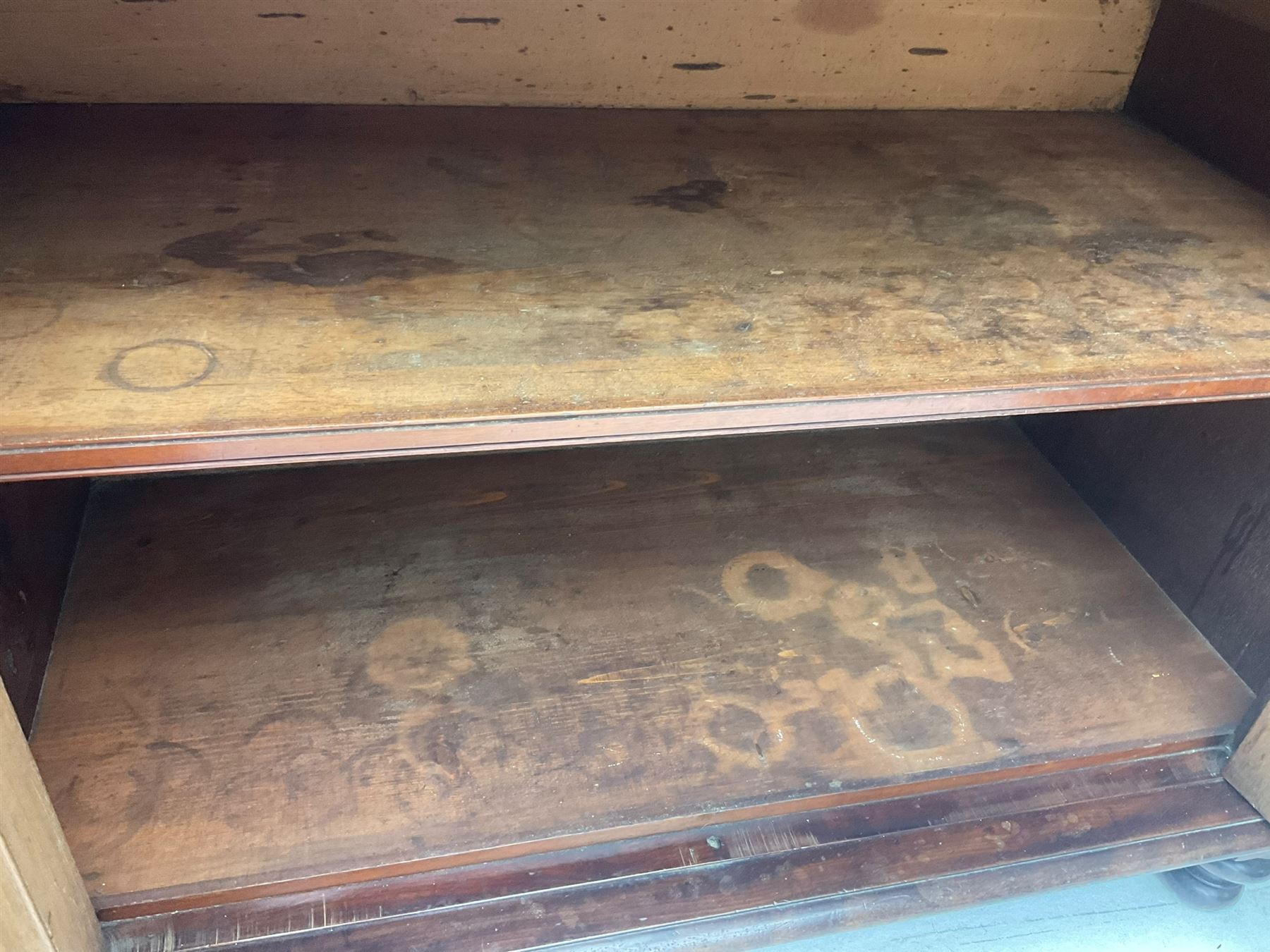 Early 19th century figured mahogany bureau bookcase, projecting splay moulded cornice over three adjustable shelves enclosed by two glazed doors, fall front revealing pigeonholes, cupboard and drawers, pull-out strays with scroll carved terminals, double cupboard with two panelled doors, on turned feet 