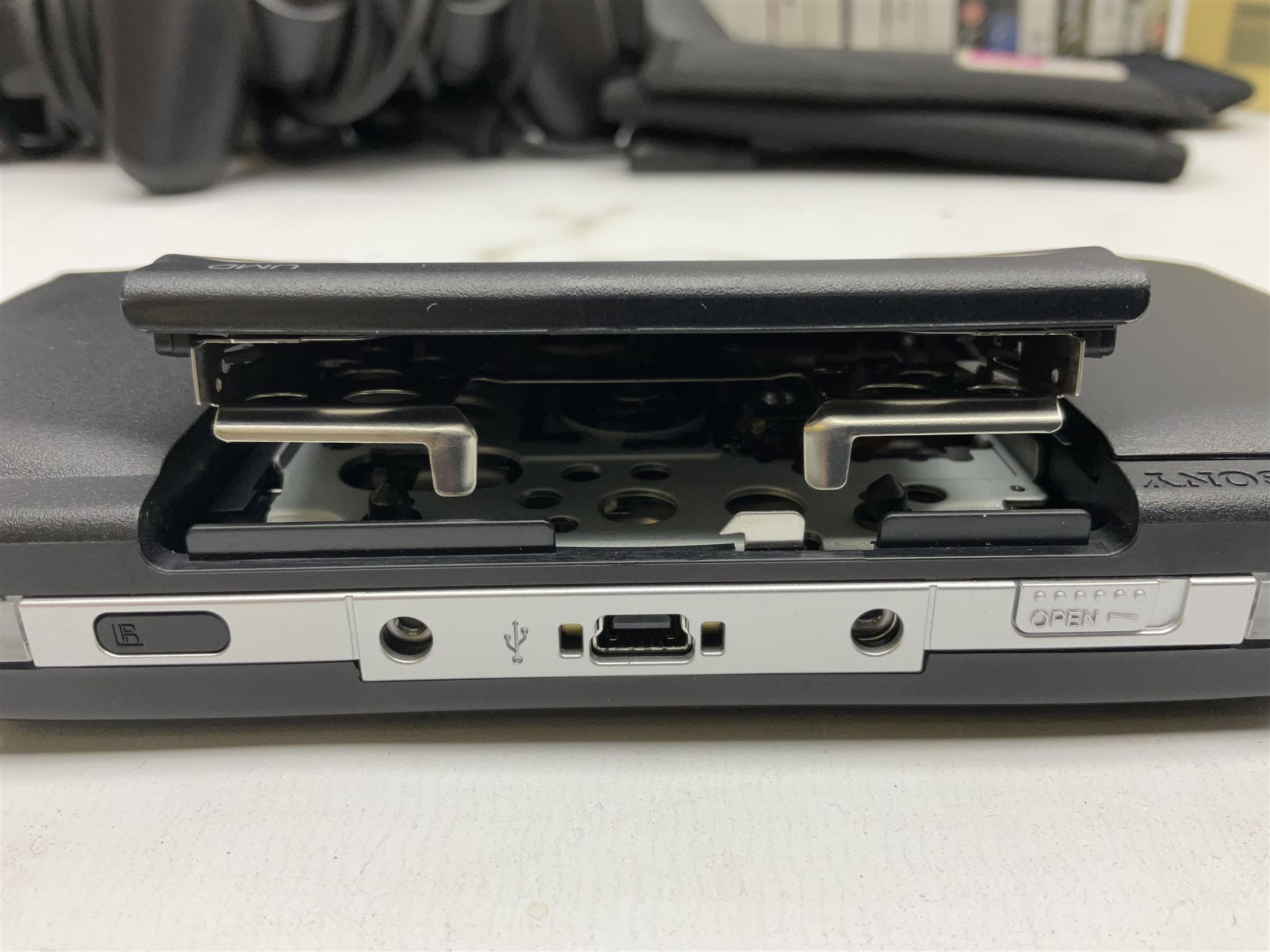 Sony PlayStation 3 60GB console with one PS3 controller, two PS2 controllers, BD remote control, PSP handheld gaming console with case, GAMEware PSP essentials pack, and a selection of PS2, PS3 and PSP games in original cases with instruction booklets 