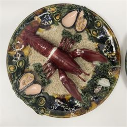 Two 20th Century Portuguese Palissy style Majolica wall plates, one depicting a crab, the other a lobster each to the centre modelled in relief surrounded by encrustations and shells, both with impress marks beneath, D32cm