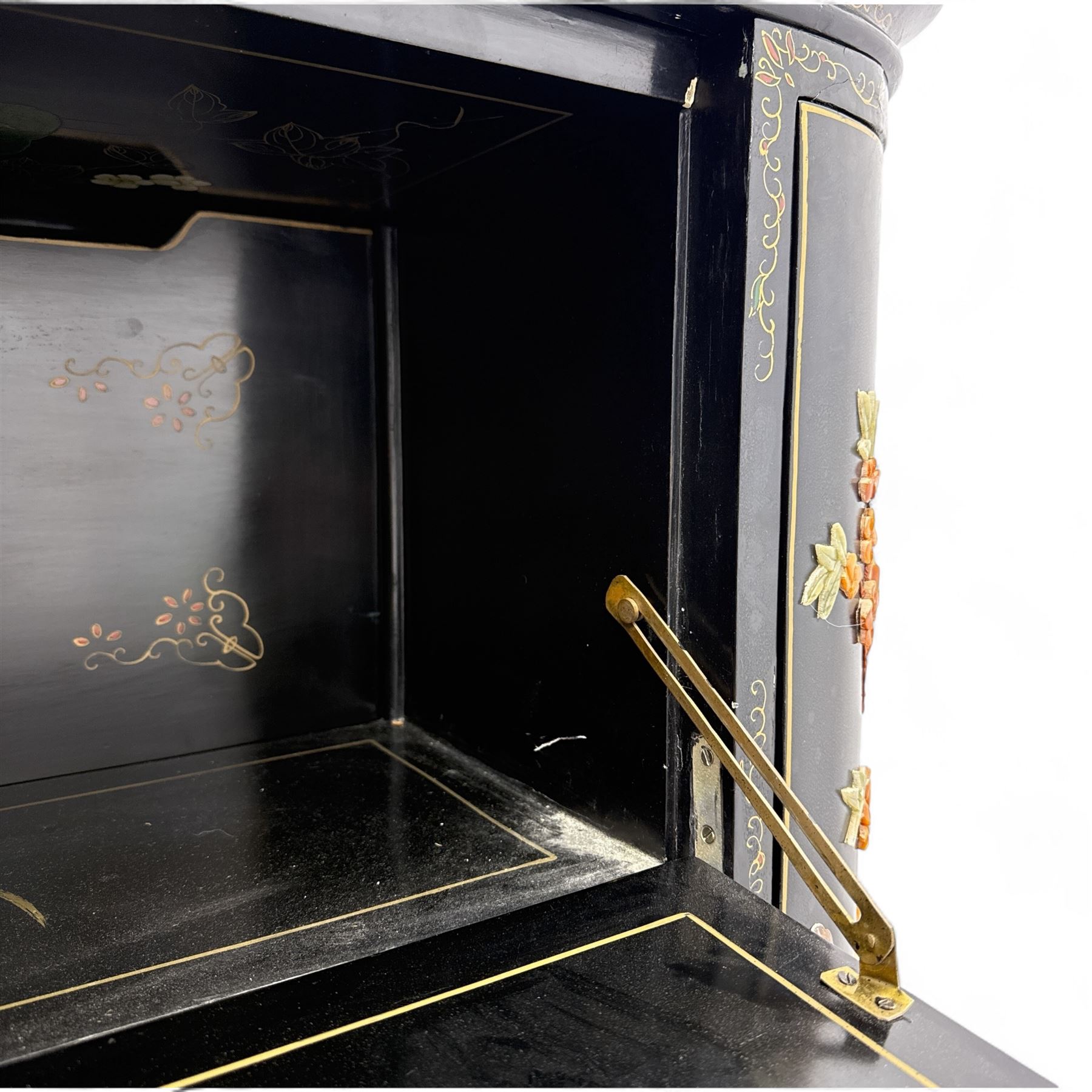 Early 20th century Chinoiserie lacquered cabinet, rounded rectangular top above a fall front enclosing fitted interior with lacquered decoration, over a pair of cupboard doors and flanked by side compartments with tiered bottle shelves, the black lacquer ground decorated throughout with raised and painted floral sprays, on shaped bracket feet