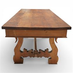 20th century Spanish design oak dining table, large rectangular top above a run of three drawers to the frieze, standing on shaped trestle supports with scroll cut details and stretcher base