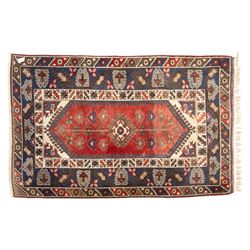 Caucasian Shirvan hand-knotted rug, red madder field with hooked lozenge medallions and stylized motifs, framed by ivory stepped spandrels and multiple geometric borders in indigo brown and ivory, with serrated palmettes and angular devices 