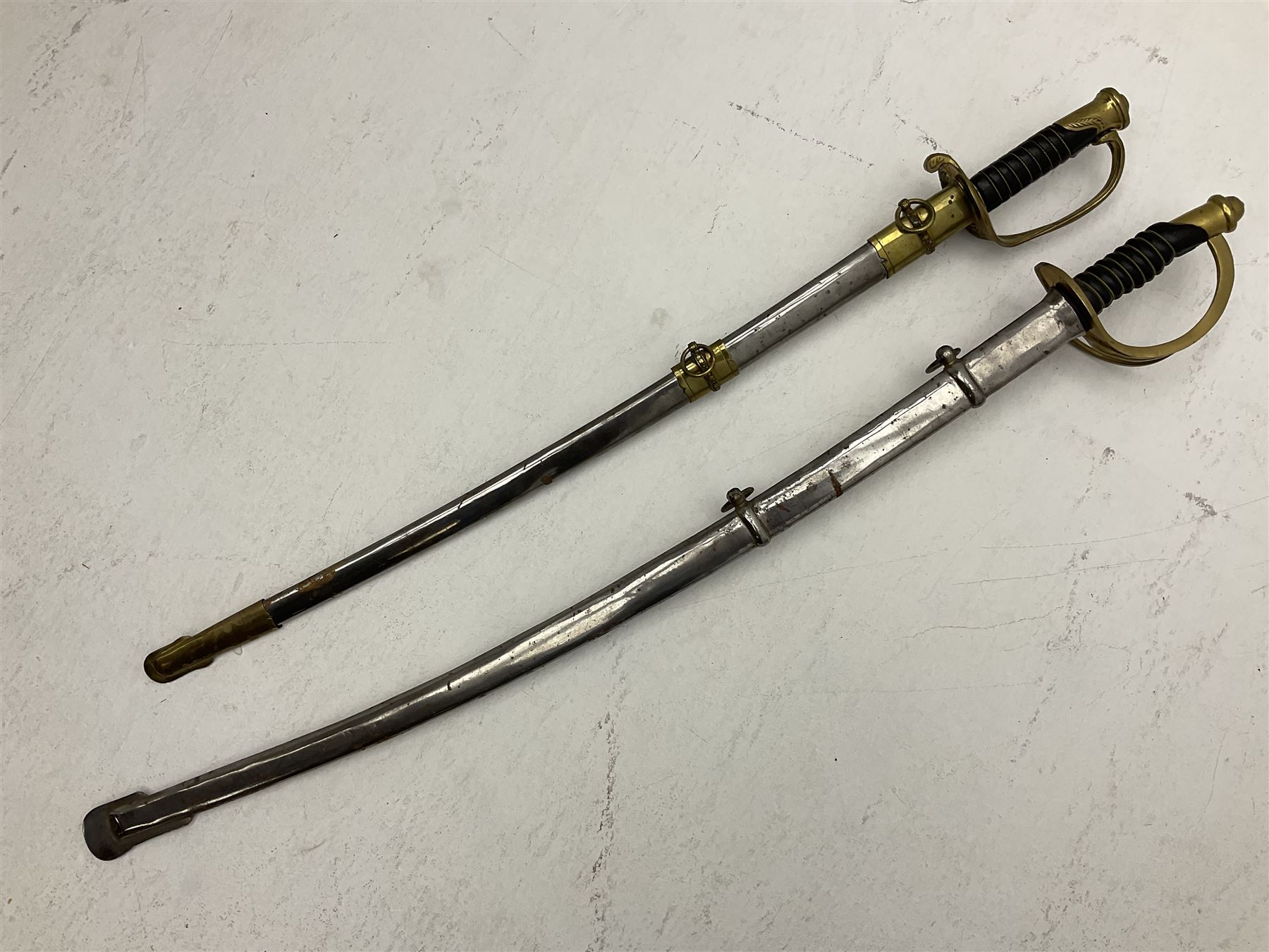 Reproduction American Civil War Cavalry trooper's sword, the 88cm slightly curving fullered steel blade marked to the ricasso 'Ames & Co Chicopee Mass.' and 'US ADK 1862'; brass hilt and leather covered grip; in steel scabbard L110cm overall;  and another reproduction sword (2)