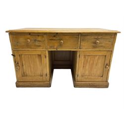Large pine knee hole desk, rectangular moulded top over three drawers and two cupboards, panelled sides and back, on plinth base