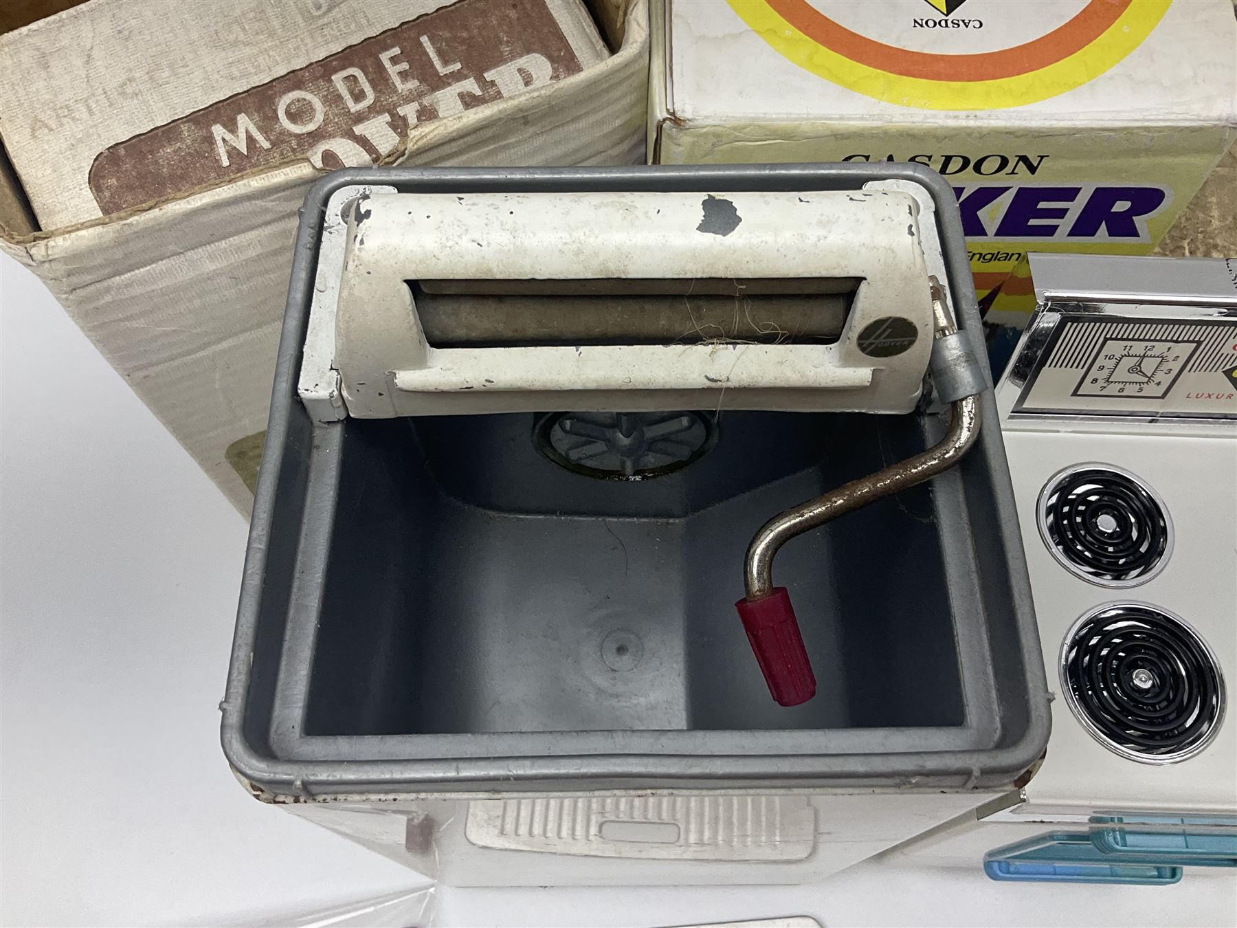 Six toy kitchen appliances - Casdon battery operated cooker; Mettoy Hoover washer; Chad Valley Hoovermatic washer; Wells Brimtoy tin-plate clockwork washer; and two Morphy Richards irons; together with a continental child's Regina sewing machine; all boxed (7)